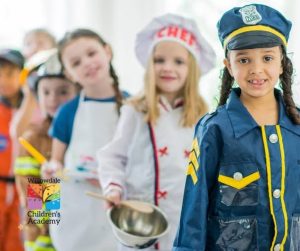 کودک خردسال در حال بازی وانمودی آشپزخانهای با قابلمه و غذای اسباببازی
